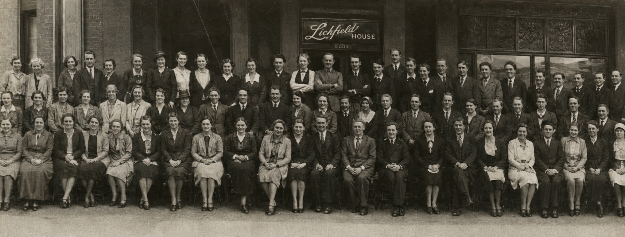Vintage-style black-and-white photo of the Lichfield team posed outside Lichfield House — New Zealand menswear manufacturer since 1916.